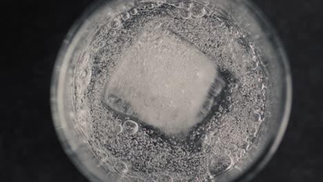 closeup ice cube glass with sparkling water in slow motion. cocktail concept