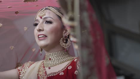 portrait of young happy indian bride with bright makeup and golden jewelry