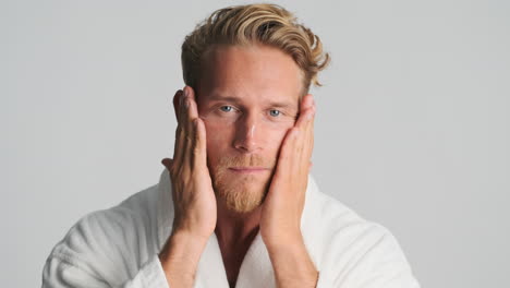 young man applying lotion to his face