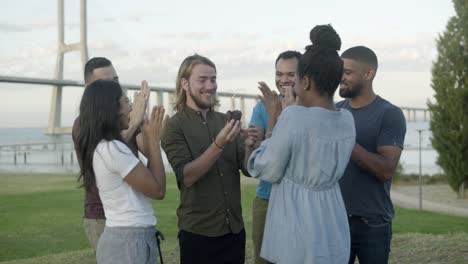 amigos sonrientes felicitando al joven barbudo por su cumpleaños