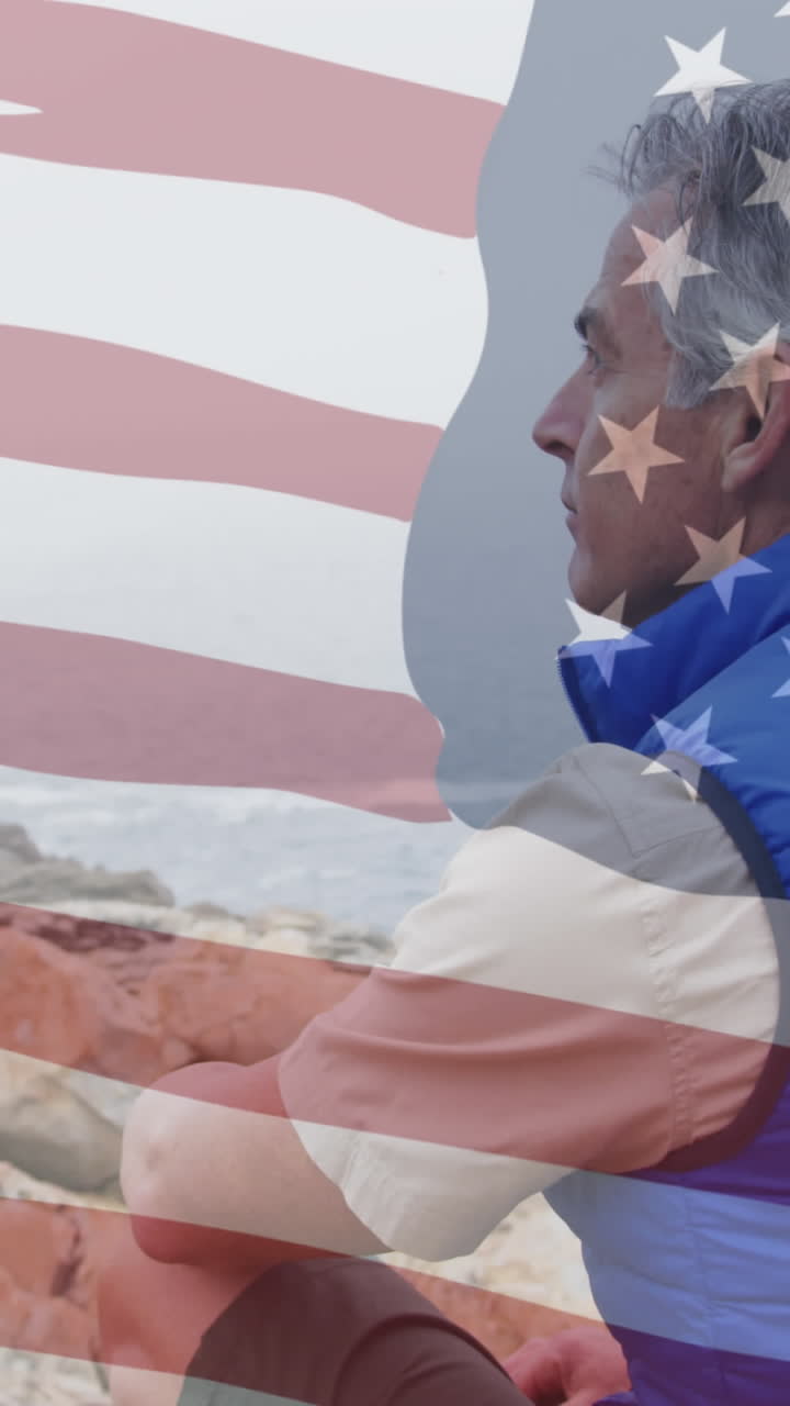 animación de la bandera estadounidense sobre un hombre caucásico sénior sentado en rocas en las montañas