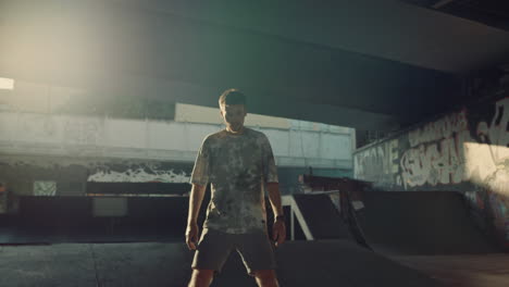 active man spinning on roller skates at skate park with graffity on wall.