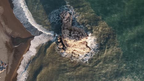 Toma-Aérea-De-Arriba-Hacia-Abajo-Del-Agua-Clara-Del-Océano-En-La-Playa-De-Arena-De-Málaga-En-España-Durante-La-Puesta-De-Sol