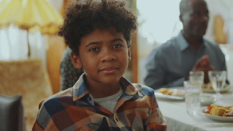 portrait of cute african american boy on family dinner at home