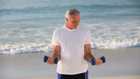 Elderly-handsome-man-working-his-muscles-with-dumbbells