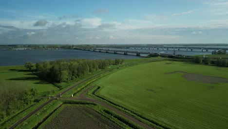 Volando-Un-Dron-Sobre-Un-Paisaje-De-Pólder-Holandés-Hacia-El-Puente-De-Moerdijk