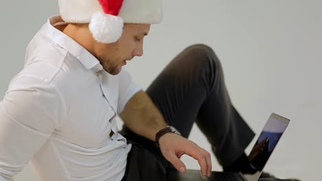 man in santa hat using laptop