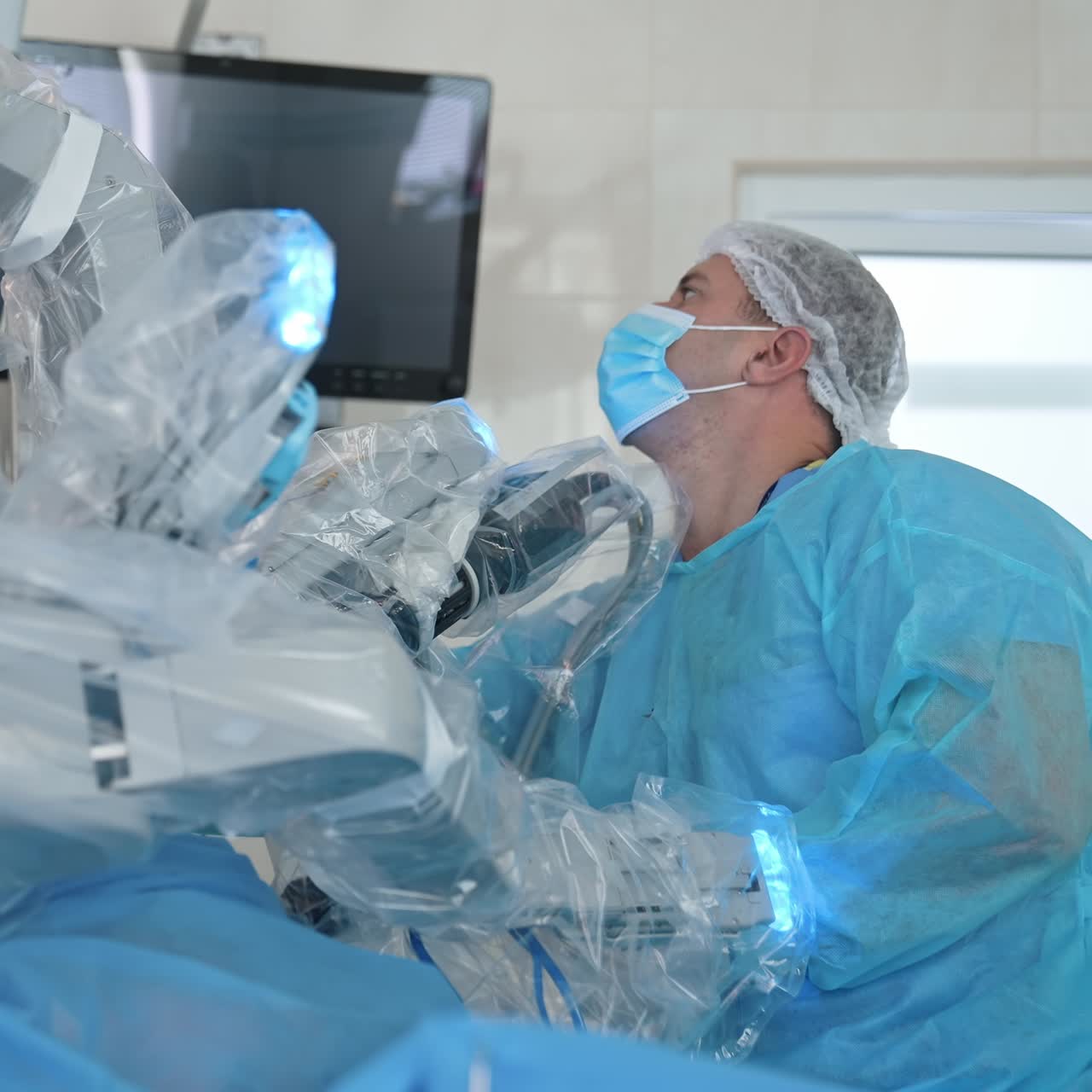 Professional surgeon near medical robot in clinic. Minimally invasive surgery with robotic equipment which is assisted by a doctor in medical uniform