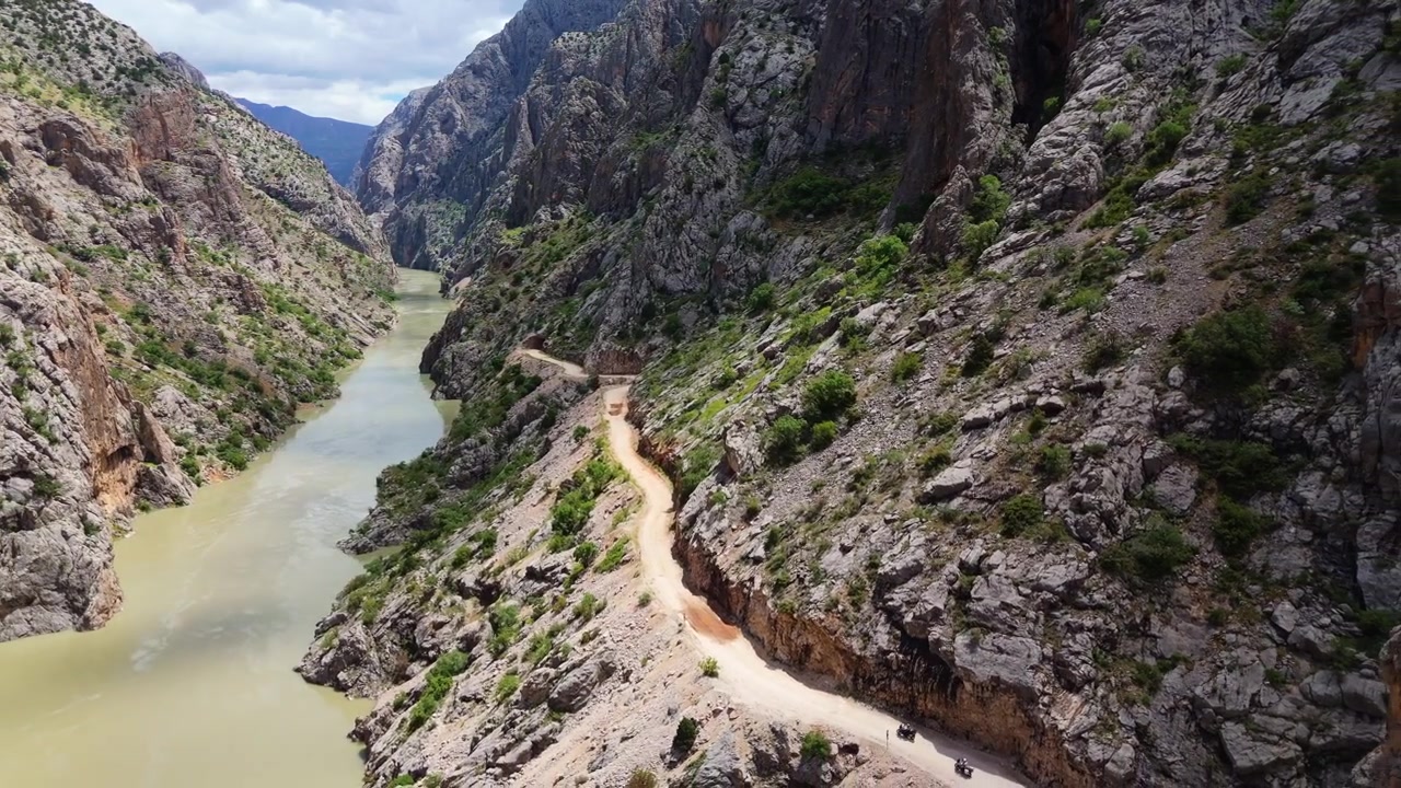 Veduta aerea del fiume Karasu con la leggendaria Strada di Pietra intagliata a mano visibile sulla scogliera con un tunnel scavato nella roccia nel Canyon a Kemaliye, Turchia. Destinazione di viaggio avventura.