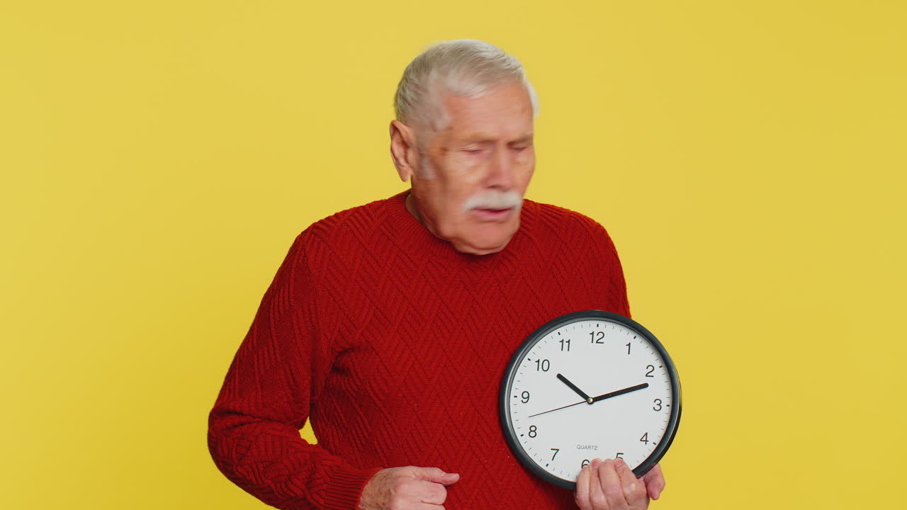 Senior old man with anxiety checking time on clock running late to work being in delay deadline