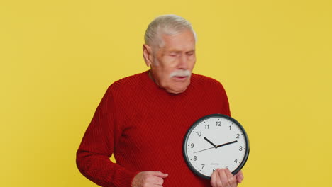 senior old man with anxiety checking time on clock running late to work being in delay deadline