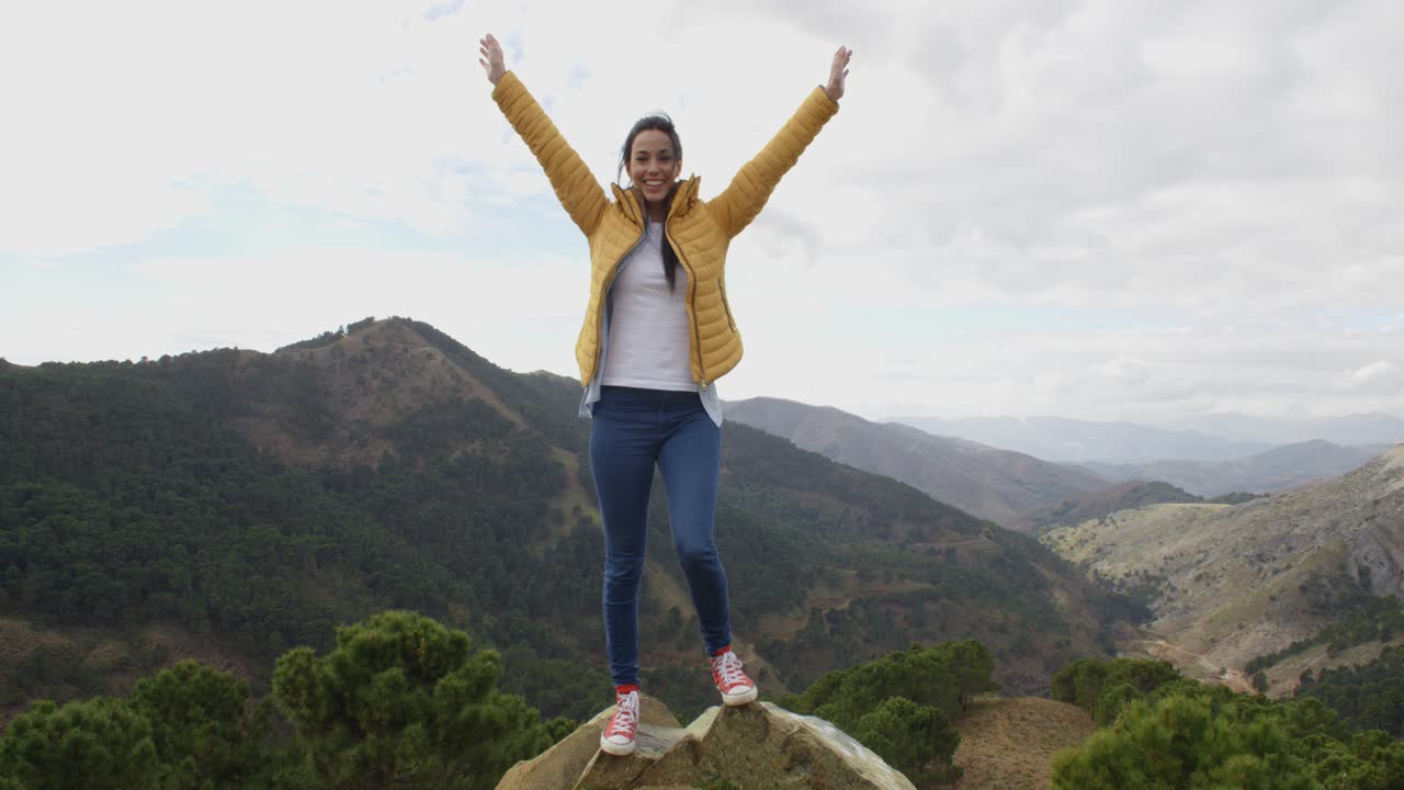 mujer excursionista regocijándose en las montañas