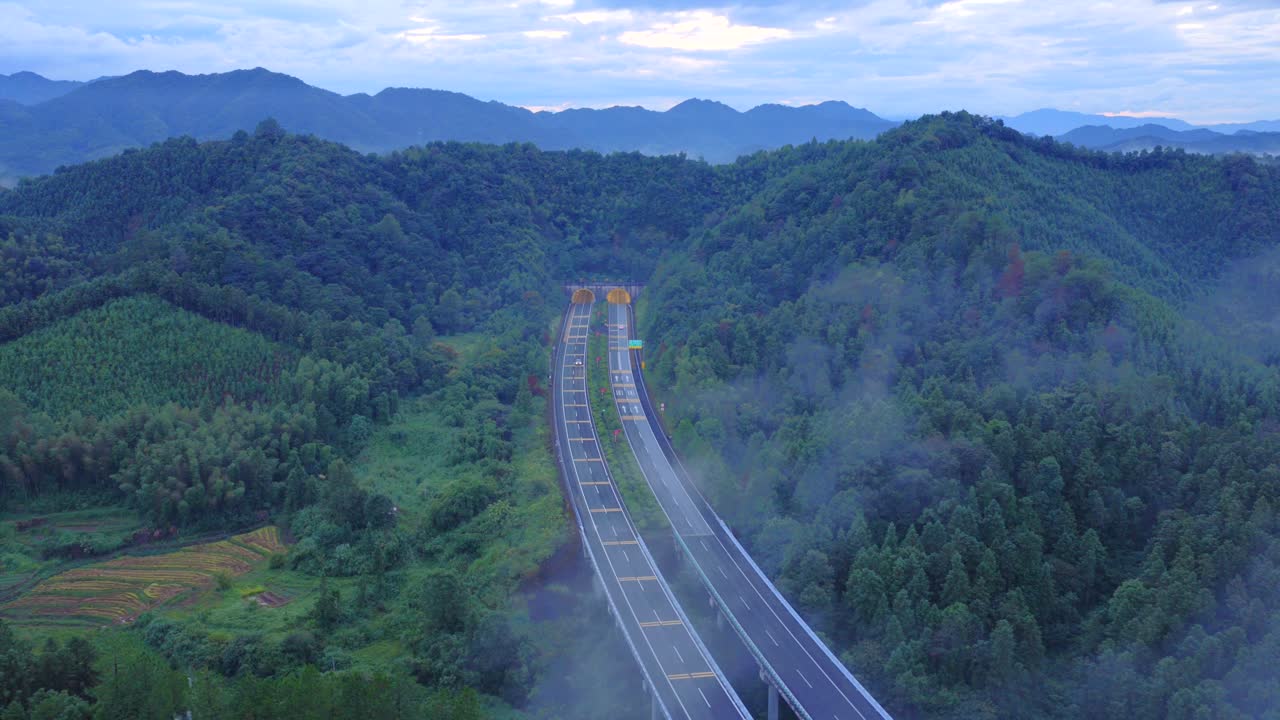 The car is driving on a foggy road, with beautiful scenery and natural scenery during the journey Aerial photography of highways under clouds and mist，