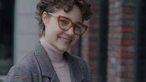 smiling woman in plaid jacket and glasses