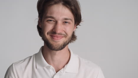 caucasian man in front of camera on gray background.