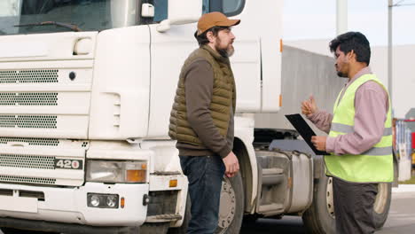 capo e lavoratore che organizzano una flotta di camion in un parco logistico