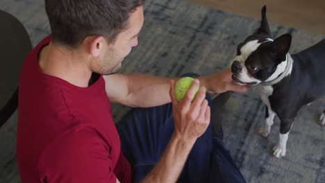 Caucasian-man-is-playing-with-his-dog-at-home