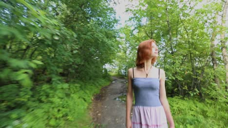 woman walking through a forest path near a lake