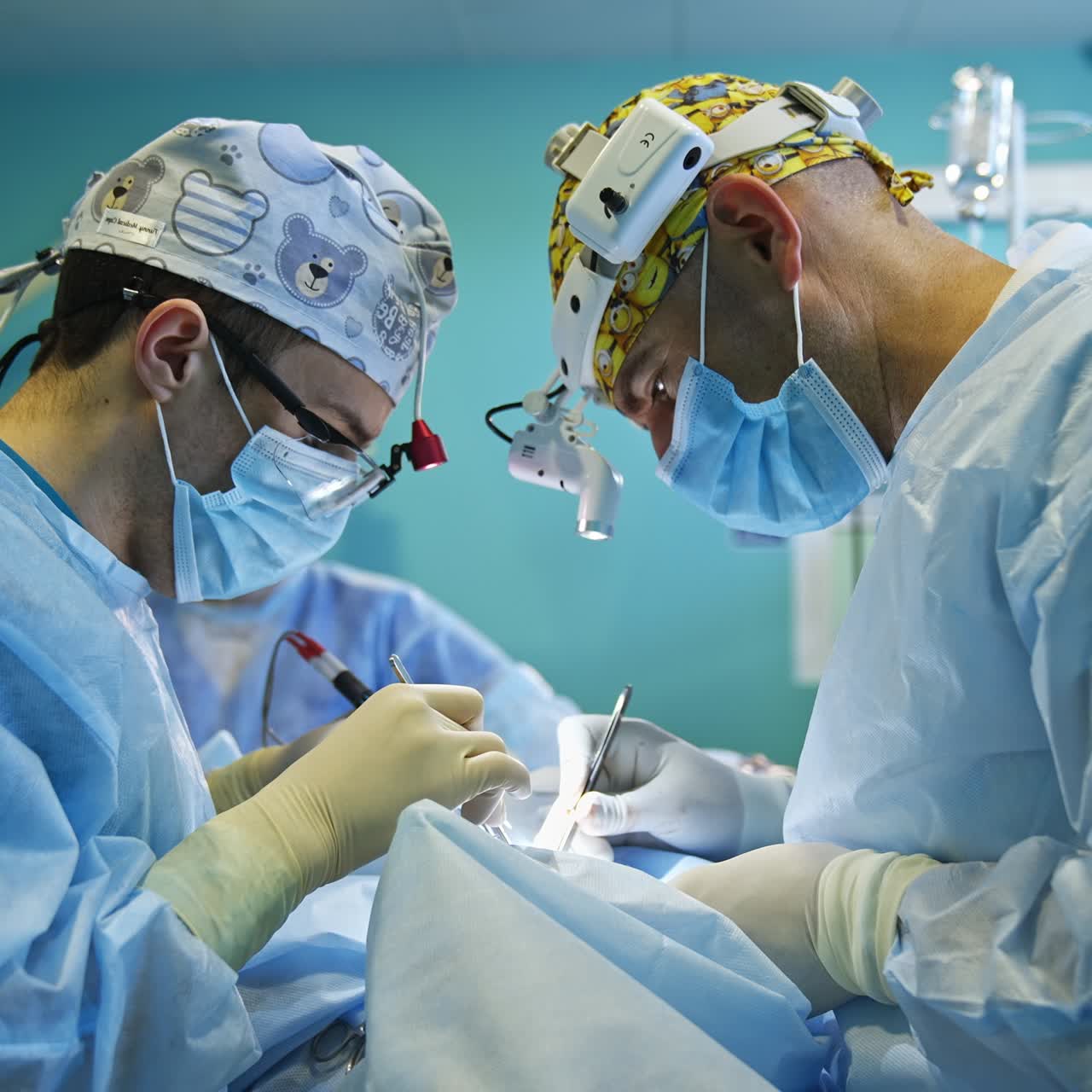 Accurate work the surgeons perform conducting operation. A pair of cooperating doctors focused on the procedure they carry out with metal tools