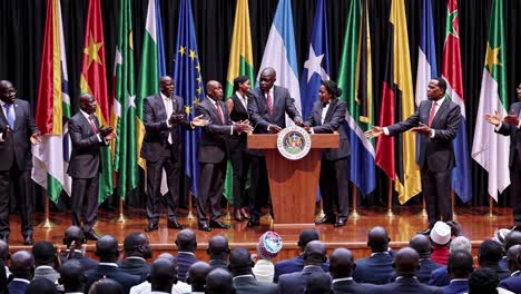high-angle video of a formal international conference with diverse leaders on stage