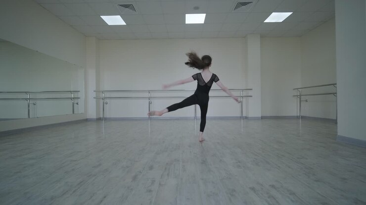 Giovane ballerina che pratica passi di danza in studio
