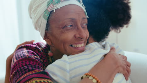 happy senior woman embracing young daughter at home
