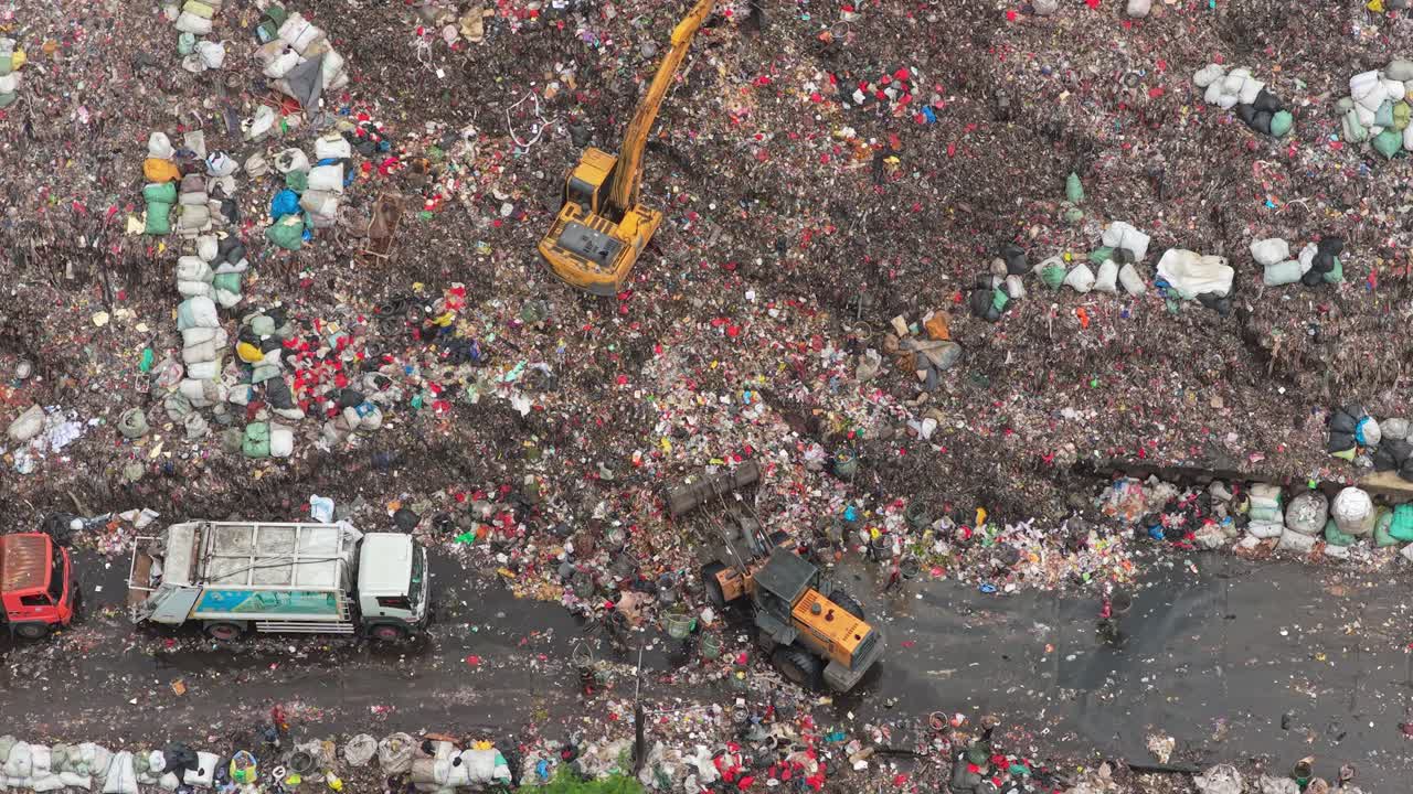 Bulldozer e macchine escavatrici al lavoro in un'enorme discarica a Jakarta