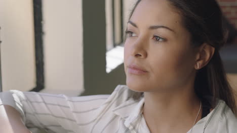 hermosa mujer hispana bebiendo café en casa disfrutando de una mañana relajada mirando por la ventana pensando contemplativamente