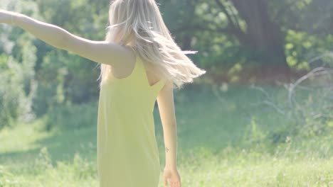 woman in yellow dress dancing gracefully in summer park