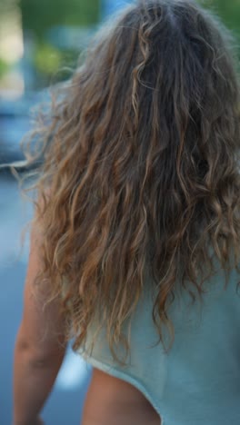 woman with curly hair wearing a light green dress