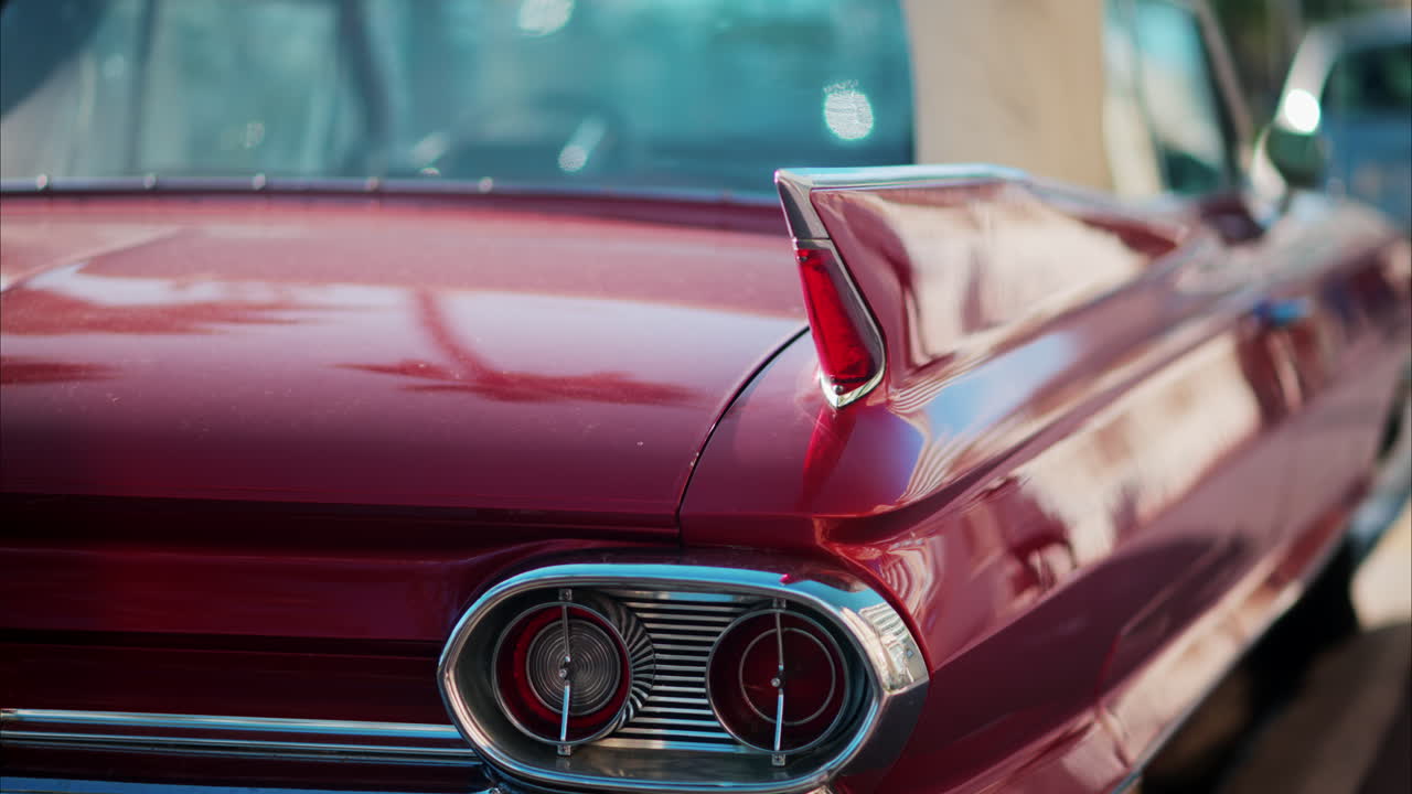 Close up of the side of a burgundy, retro car parked on the street