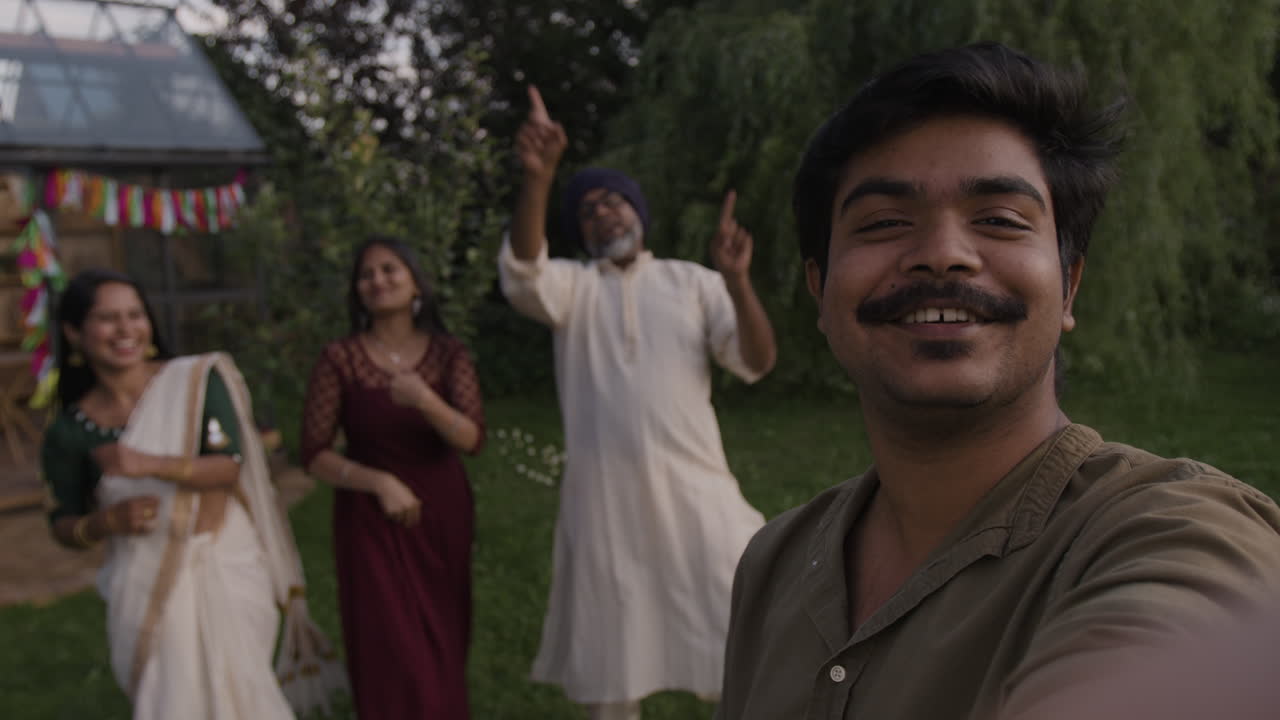 Joyful Indian family dancing and celebrating outdoors while taking a selfie