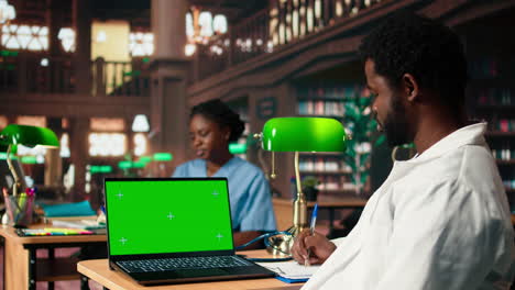 med school student works on his thesis next to isolated mockup display