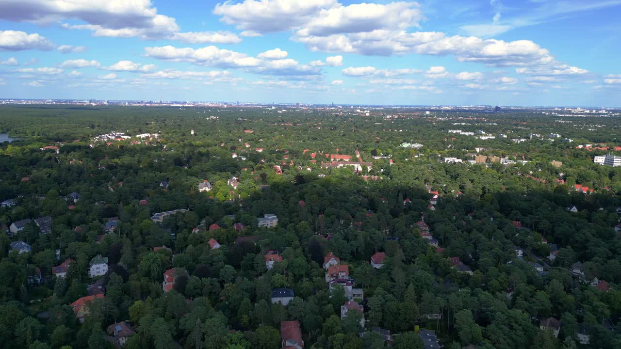 nikolassee, a residential district in berlin, featuring houses nestled within a dense forest, with the city skyline visible on the horizon. Great aerial view flight speed ramp hyper motion time lapse