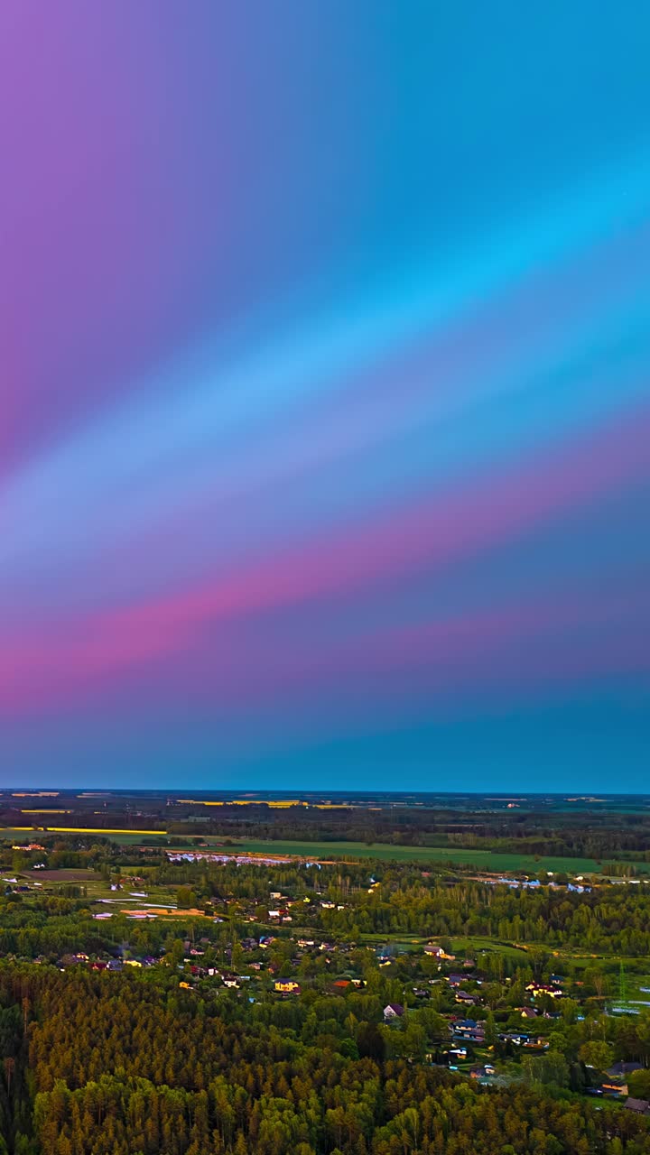 A serene landscape at sunset with a smooth gradient of colors in the sky over rural areas