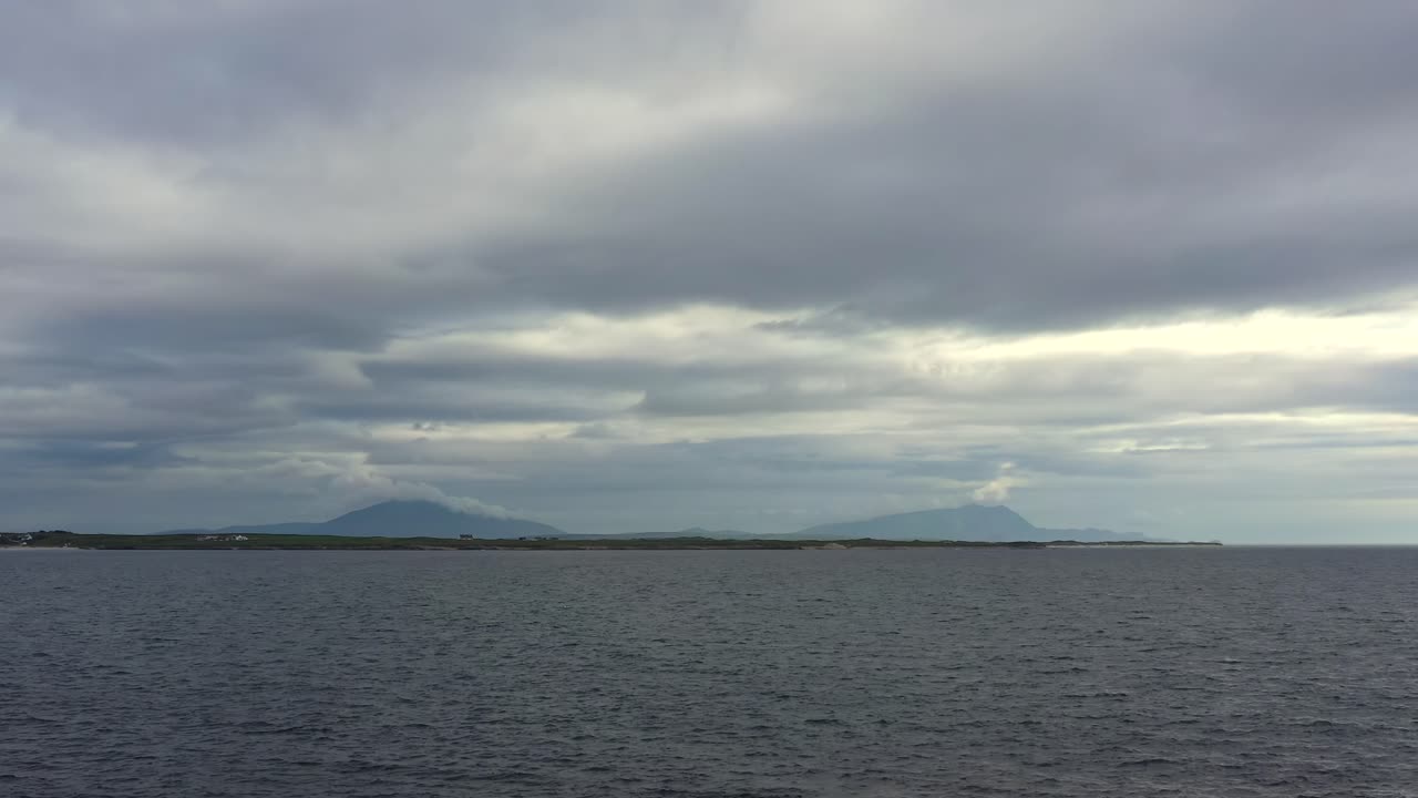 Aerial dolly over open Atlantic Ocean with the mountains of County Mayo rising on the distant horizon