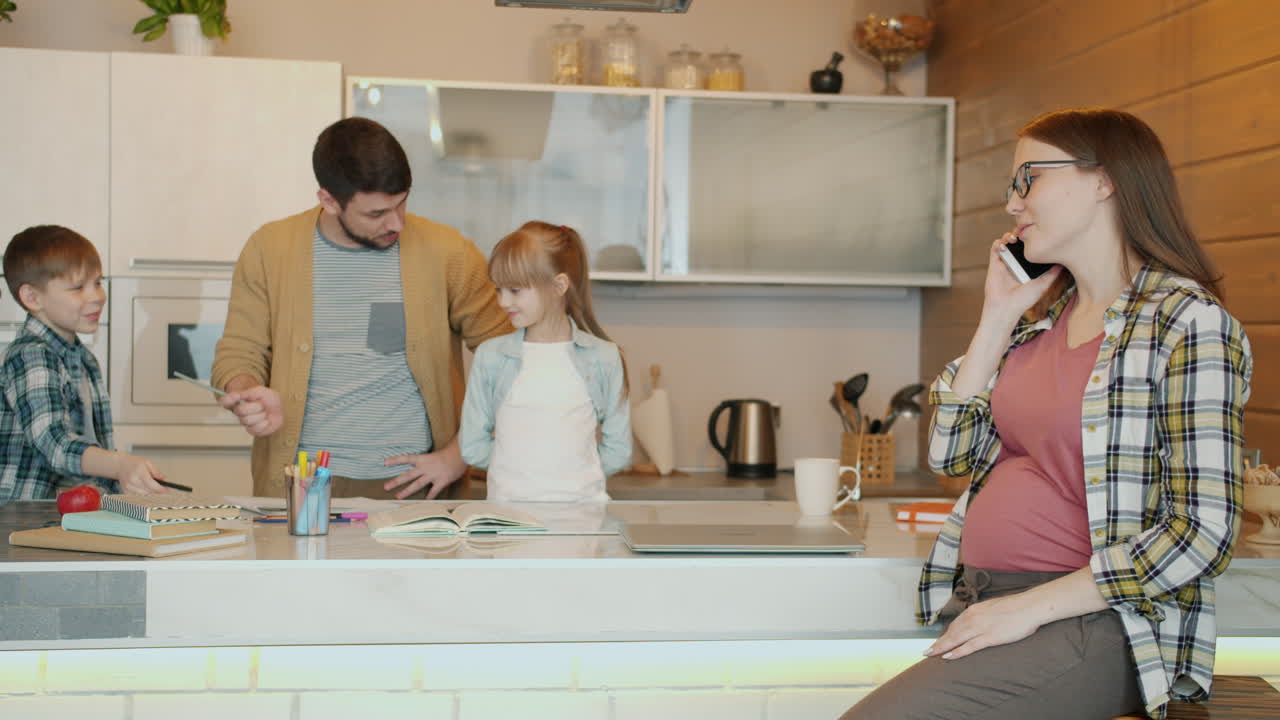 Family working and pregnant woman in the kitchen