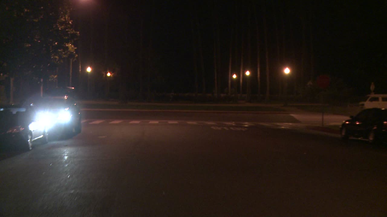 뒷 창문을 통해 보이는 로스앤젤레스 캘리포니아의 밤 거리를 따라 자동차가 이동합니다.