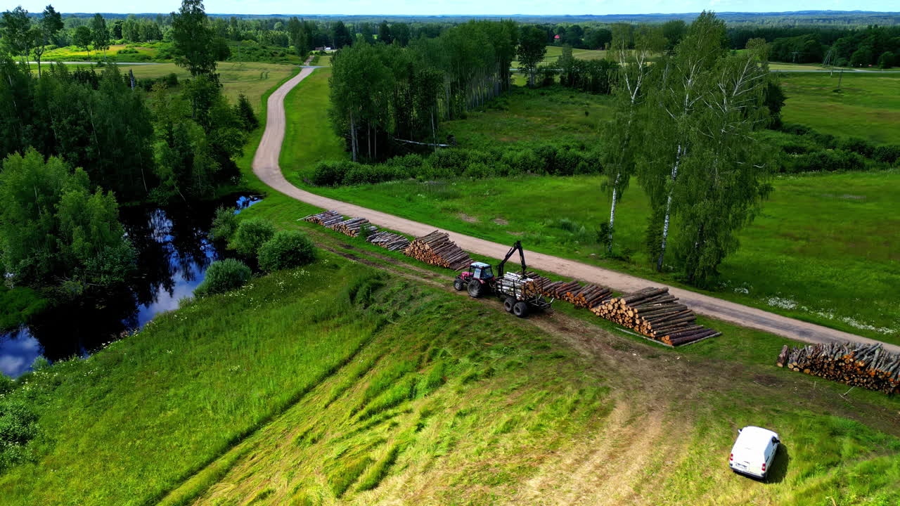Aerial View of Logging Operations with Tractor and Stacks of Timber in a Rural Landscape