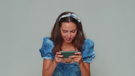 Worried-funny-young-woman-enthusiastically-playing-racing-or-shooter-video-games-on-smartphone