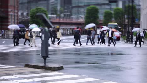 walking people on the street in marunouchi tokyo rainy day