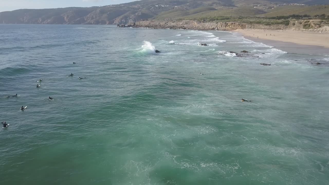 vista aérea aérea con surfistas y olas en el océano en la costa de portugal