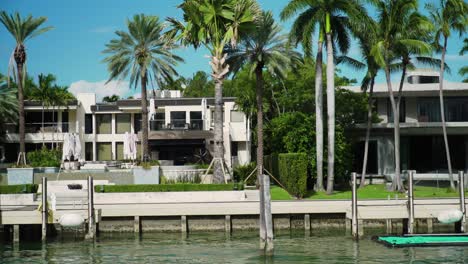 waterfront homes on star island in miami day time with palm trees, blues skies