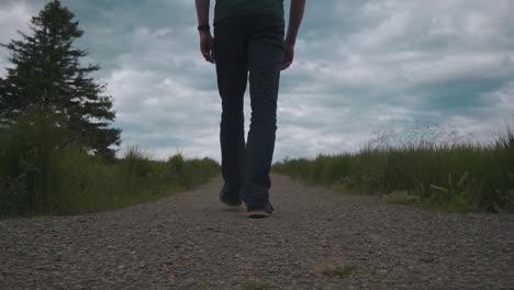 man walking on a little path in the middle of the nature