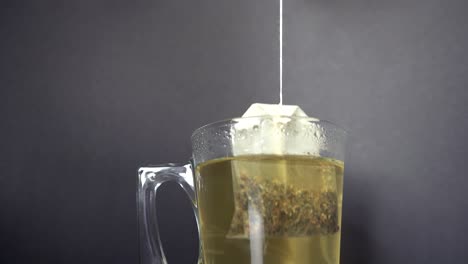 Hot-steaming-tea-is-prepared-and-brewed-in-a-glass-against-a-dark-background