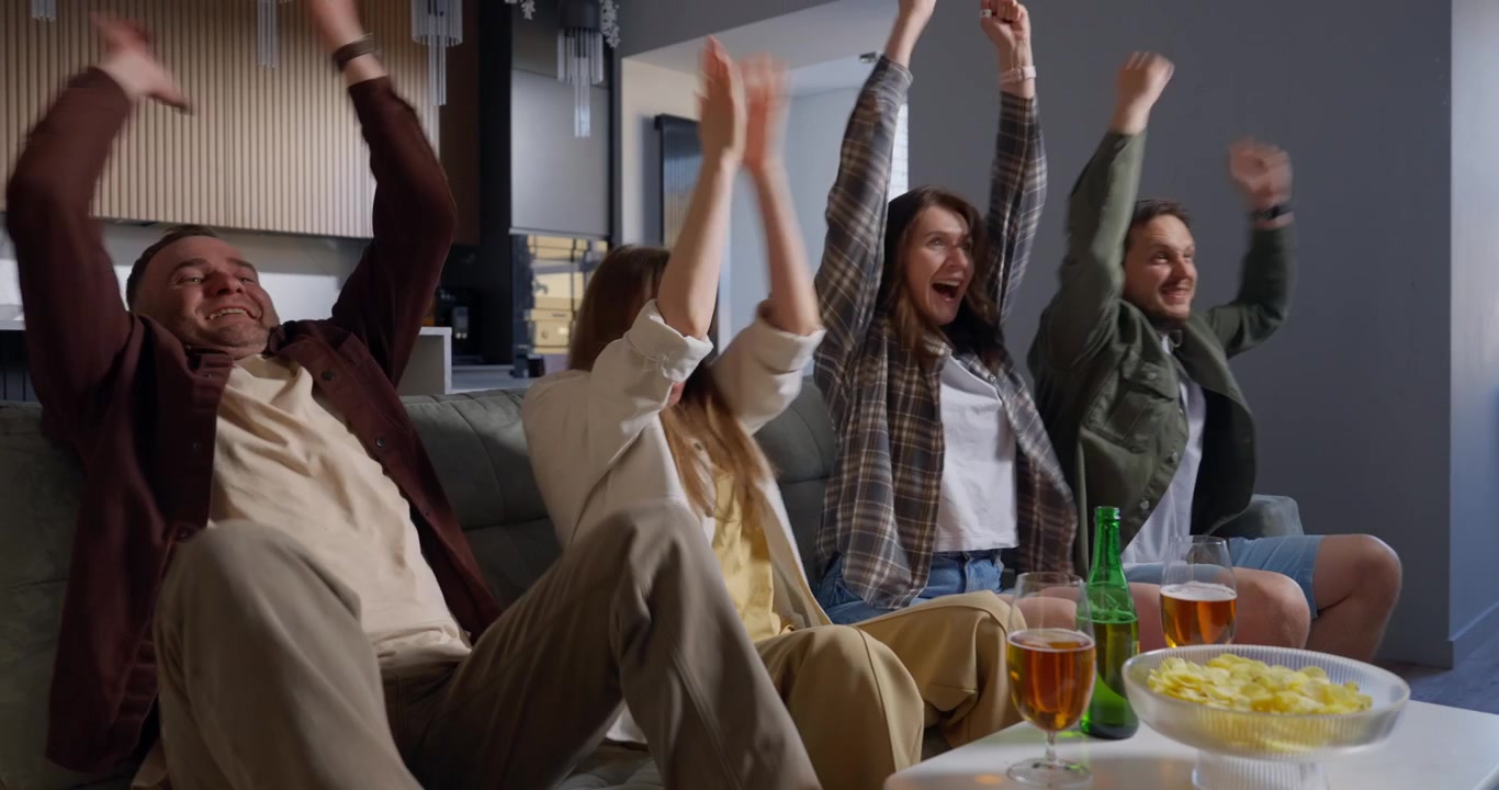Excited Friends Cheering and Celebrating While Watching TV at Home