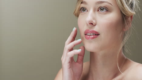 portrait of caucasian woman with blond hair touching her face, copy space, slow motion