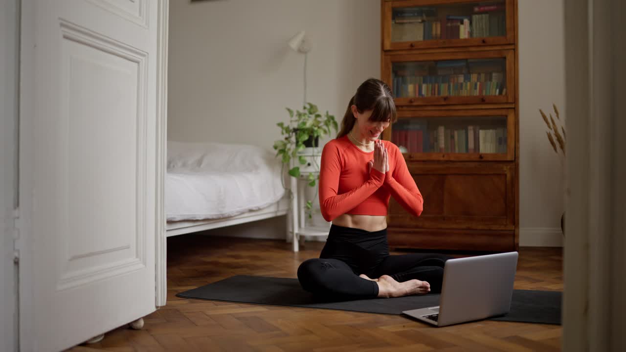 mujer practicando yoga en línea en casa