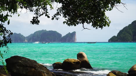 thai longtail boats drive in open bay waters, southeast asia rocky islands