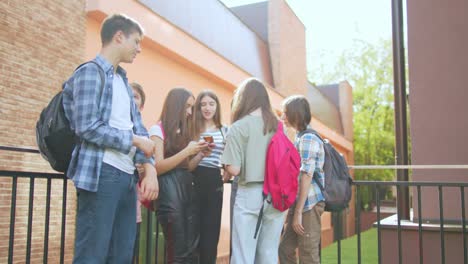 las adolescentes se divierten y conversan usando sus teléfonos móviles